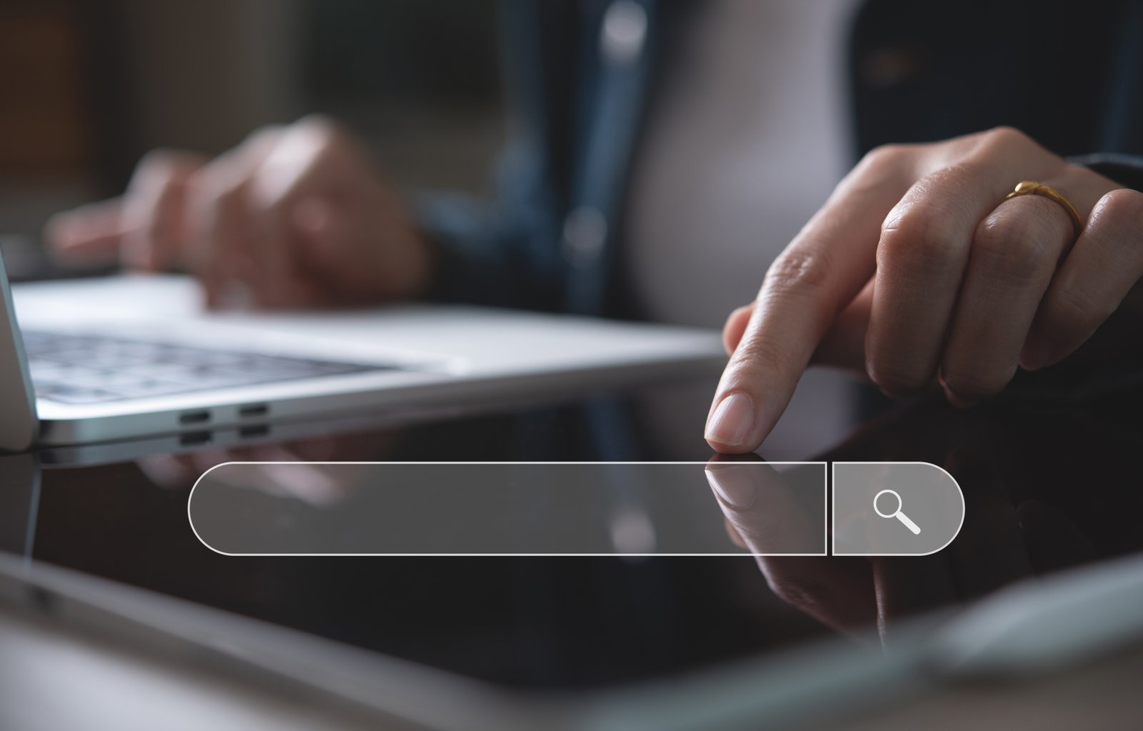 Data Search Technology Search Engine Optimization SEO concept. B Person's finger taps a glassy touchscreen search bar with a magnifying-glass icon on a laptop-like surface in the background