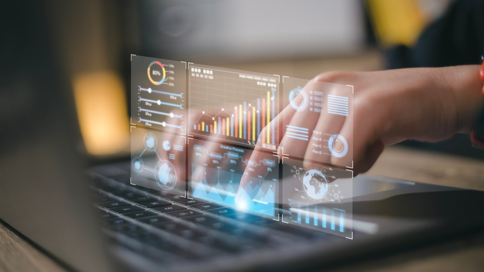 Data analyst working on business analytics dashboard with charts Person's hand touches translucent holographic dashboards with charts and graphs over a laptop keyboard, illustrating data analytics in use.